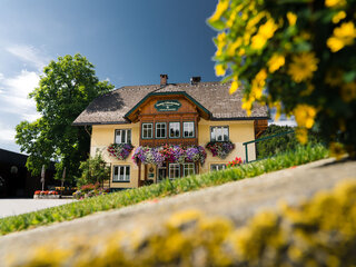 Vor dem Haus vom Glitschnerhof sieht man Blumen im Vordergrund